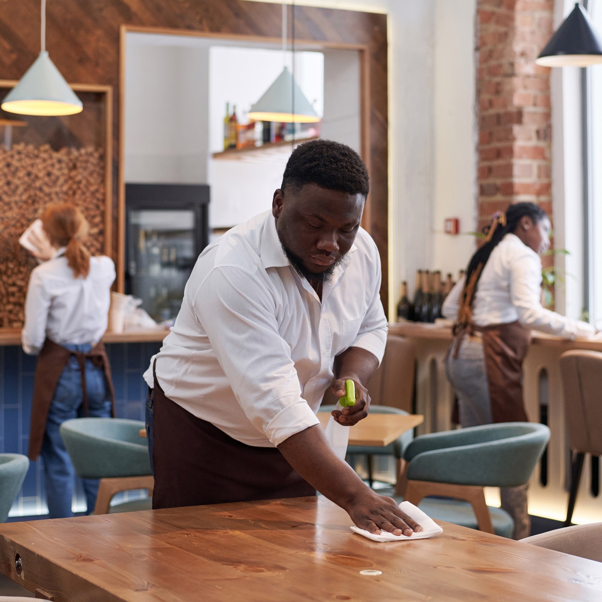 black-man-cleaning-table-in-modern-cafe-2024-03-19-19-05-55-utc